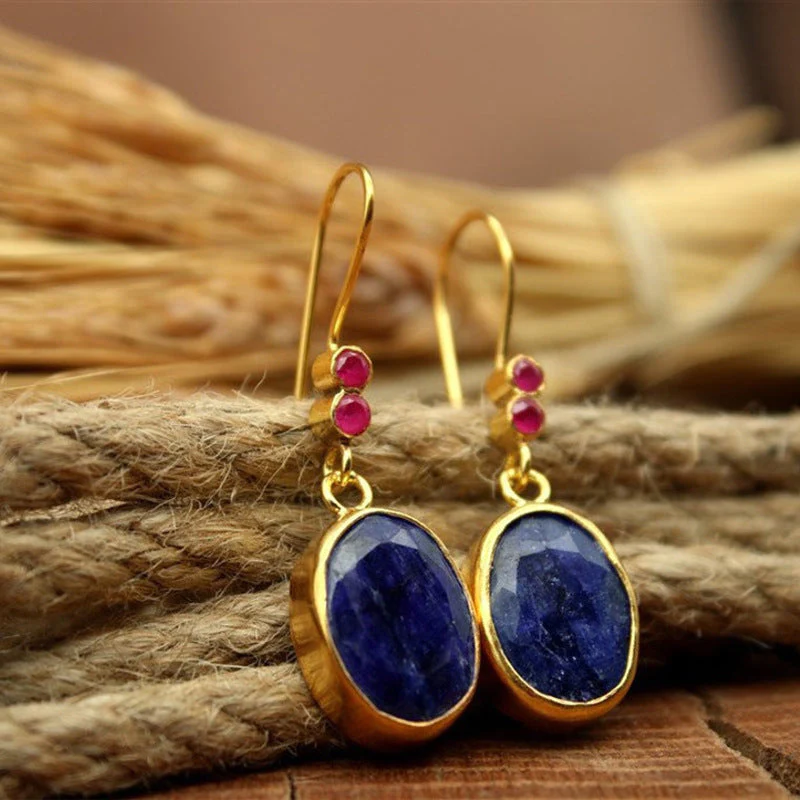 Éblouissantes boucles d'oreilles vintage en or ornées d'une précieuse pierre bleue profonde